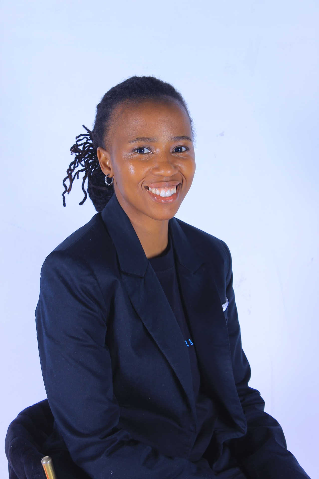 Portrait of Nobelungu Msimango, Founder and CEO of Charge All Africa, smiling and wearing a dark blazer